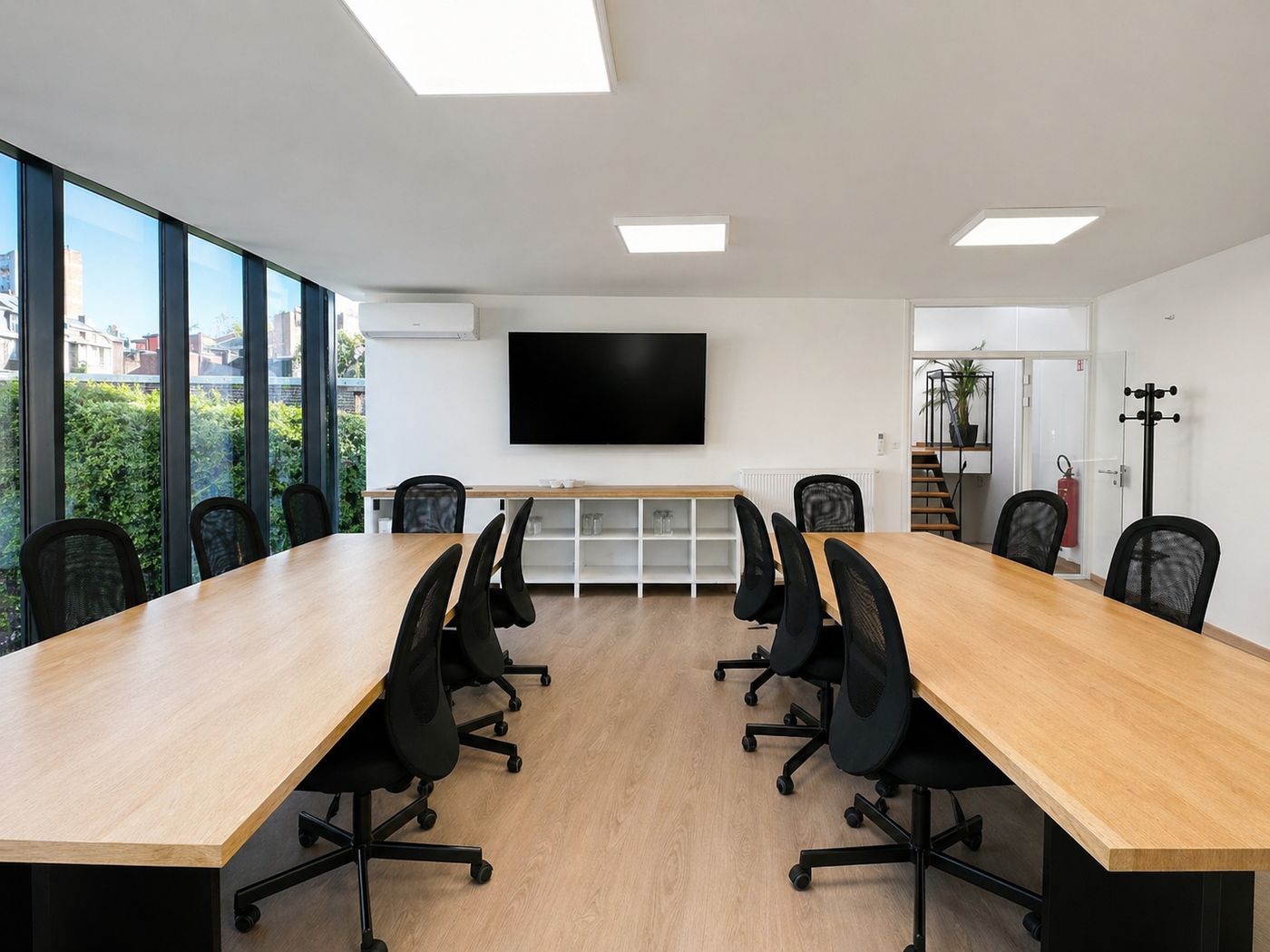 Salle Gramme d’OR21 : deux longues tables en bois, grand écran, baie vitrée sur un jardin
