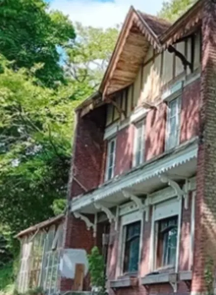 Détail de la photo de la Ville : le pignon sud-ouest en brique dépasse la façade au-dessus de la verrière.